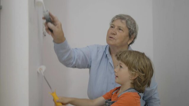 Portrait of old woman and little grandchild whitewashes the walls