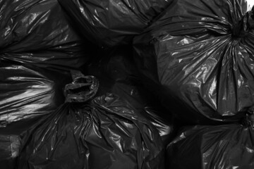 Fototapeta na wymiar Black trash bags full of garbage as background, top view