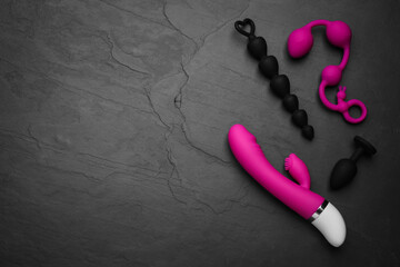 Sex toys on black background, flat lay. Space for text