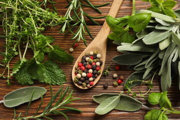Different fresh herbs and spices on wooden table, flat lay