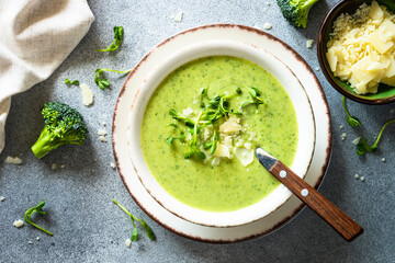 Broccoli cream soup with cream, greens and parmesan. Healthy green soup, vegan dish. Top view at...