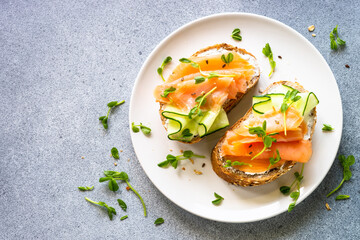 Open sandwich with cream cheese, salmon and cucumber. Healthy breakfast or snack. Top view with copy space.