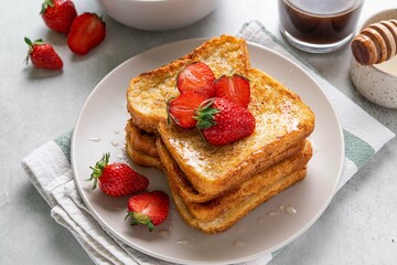 Homemade french cinnamon toast with strawberries, honey and coffee. Morning breakfast, brunch or lunch concept. Selective focus.