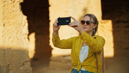 Woman shooting video via smartphone on excursion.