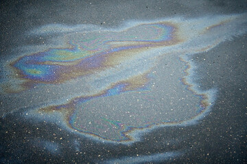 Gasoline oil spill on the pavement as a texture or background. Environmental pollution concept