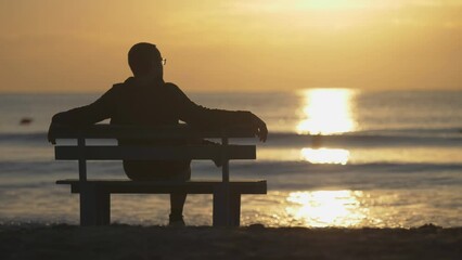 Man sit on bench look at waving sea, sun rising, bird fly, feel nature beauty