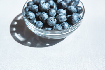Blue blueberries in glass bowl from the top view, food background with copy space