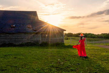 A woman with red dress and straw hat is enjoying subset 