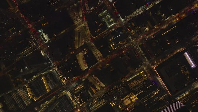 Aerial birds eye overhead top down view of heavy traffic in streets of night city. Fly above borough with regular grid of streets. Manhattan, New York City, USA