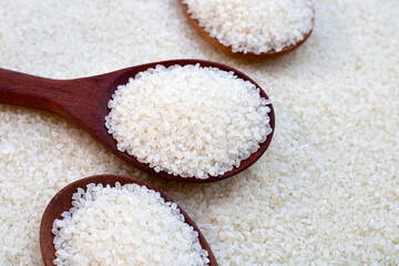 uncooked japan rice with wooden spoon