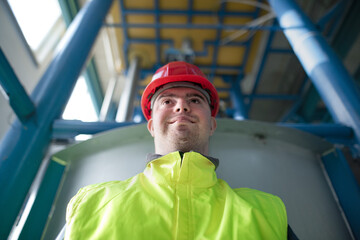 Young man with Down syndrome working in industrial factory, social integration concept.