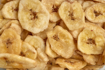 Banana chips background top view. Dried banana slices texture. Heap of dried bananas.