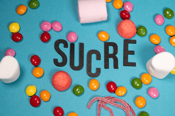 sucre écrit sur fond bleu et bonbons