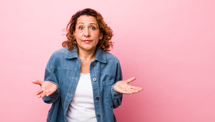 middle age hispanic woman feeling puzzled and confused, unsure about the correct answer or...