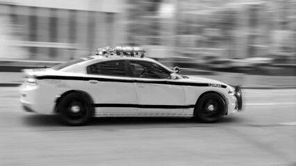 Fototapeta na wymiar Police car moving fast on city street