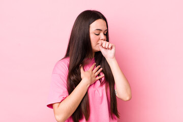young adult woman feeling ill with a sore throat and flu symptoms, coughing with mouth covered