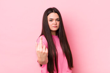 young adult woman feeling angry, annoyed, rebellious and aggressive, flipping the middle finger, fighting back