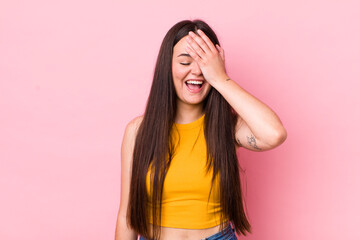 young adult woman laughing and slapping forehead like saying d’oh! I forgot or that was a stupid mistake - obrazy, fototapety, plakaty