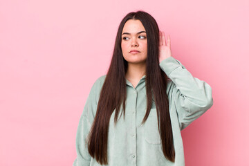 young adult woman looking serious and curious, listening, trying to hear a secret conversation or...