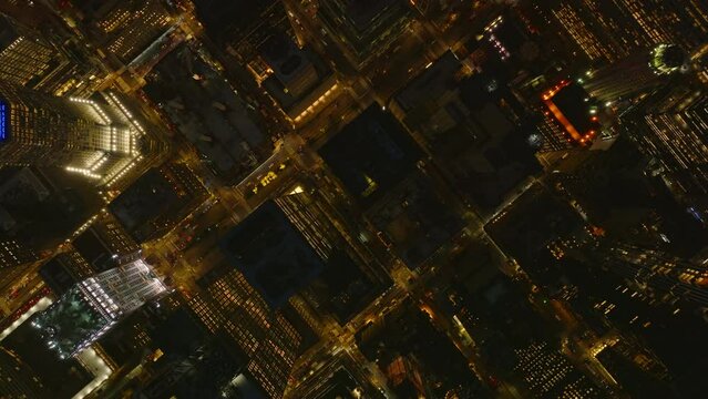 Aerial birds eye overhead top down view of illuminated streets and high rise apartment buildings in night city. Manhattan, New York City, USA