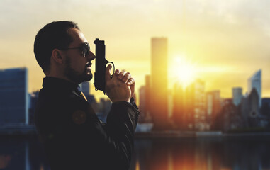 Mafia guy holding a gun in a metropolis at sunset