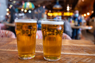 Fresh draught lager beer is glass served in indoor cafe