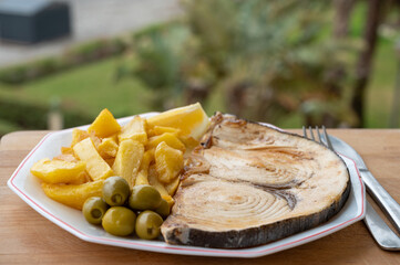 Seafood dish served in beach cafe with sea view, grilled steak from swordfish or spada served with french fried potatoes and green olives