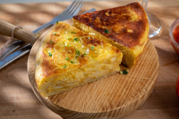 Spanish vegetarian food, portion of homemade potato omelette tortilla de patatas with onion served outdoor in morning sunlights
