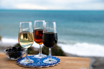 Tasting of Spanish sweet and dry fortified Vino de Jerez sherry wine and green olives with view on blue sea near El Puerto de Santa Maria, Andalusia, Spain