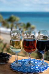 Tasting of Spanish sweet and dry fortified Vino de Jerez sherry wine and green olives with view on blue sea near El Puerto de Santa Maria, Andalusia, Spain