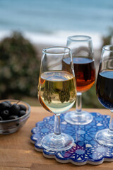 Tasting of Spanish sweet and dry fortified Vino de Jerez sherry wine and green olives with view on blue sea near El Puerto de Santa Maria, Andalusia, Spain
