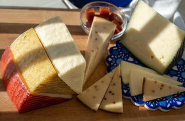 Spanish hard manchego, cow, sheep and goat cheeses served outdoor with membrillo jam in sunlights