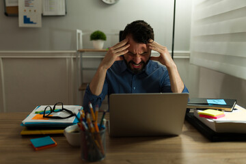 Sad man having a mental breakdown at work