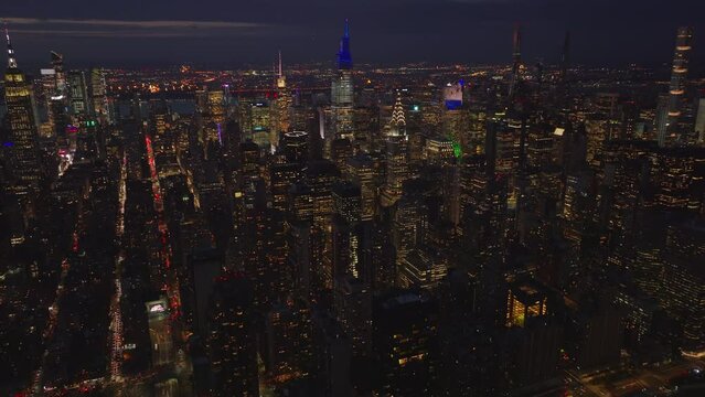 Backwards fly above evening city. Aerial panoramic footage of downtown skyscrapers. Manhattan, New York City, USA