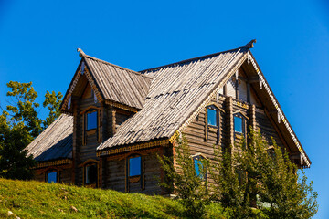 Obraz na płótnie Canvas Russian wooden hut against the blue sky. Old village hut. Peasant dwelling.