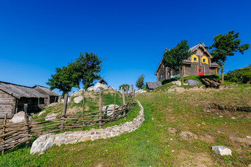 Fototapeta na wymiar Russian wooden hut against the blue sky. Old village hut. Peasant dwelling.