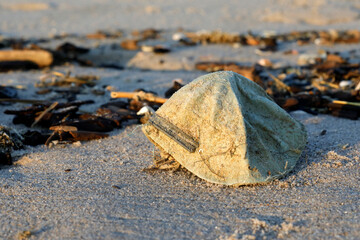 Old dust mask washed ashore on a beach