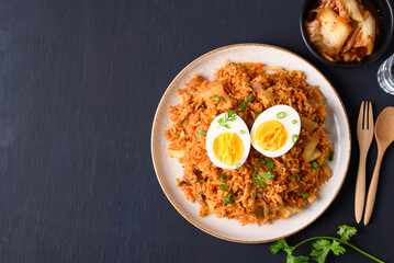 Korean kimchi fried rice with boiled egg on black background