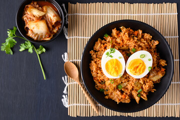 Korean kimchi fried rice with boiled egg on black background