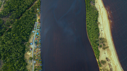 Aerial drone view of many fishing boats by the riverside in Kampung Badong, Kuala Rompin, Pahang, Malaysia.