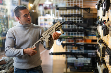 Man chooses semi-automatic pneumatic assault rifle at a gun store