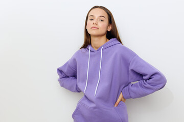 a sweet attractive woman stands on a white background in a purple tracksuit, slightly smiling, put...