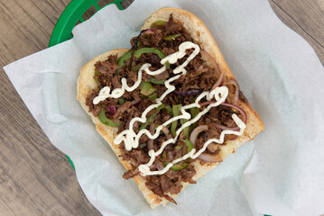 Overhead view of tradional delicious philly cheesesteak sandwich loaded with all the favorites and...
