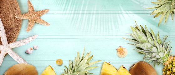 Nautical concept with palm leaf, beach hat, starfish and pineapple.