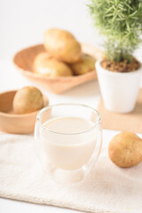 Potato milk in a glass, a healthy plant based drink on white background