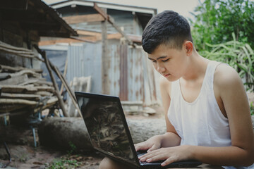 Asian boy studying online with laptop computer on his desk at home countryside, Learning with...