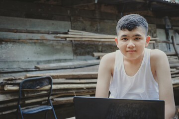 boy student studying online with laptop until his eyes look at the camera.Homeschooling distance...