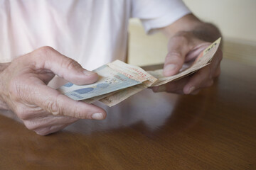 Elderly Man Counting Money. Close-up of Brazilian Real Currency.
