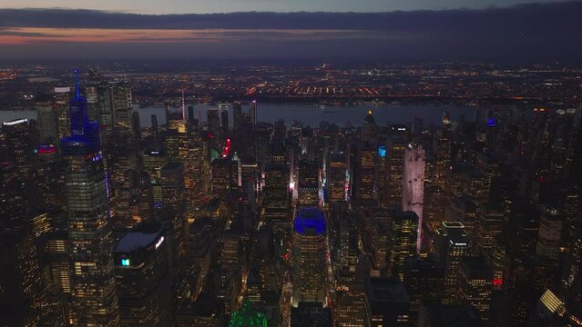 Various colour lights on skyscrapers in midtown. Aerial panoramic footage of evening cityscape. Manhattan, New York City, USA