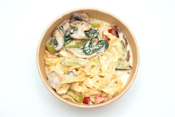 Pasta with vegetables in a cardboard lunch box